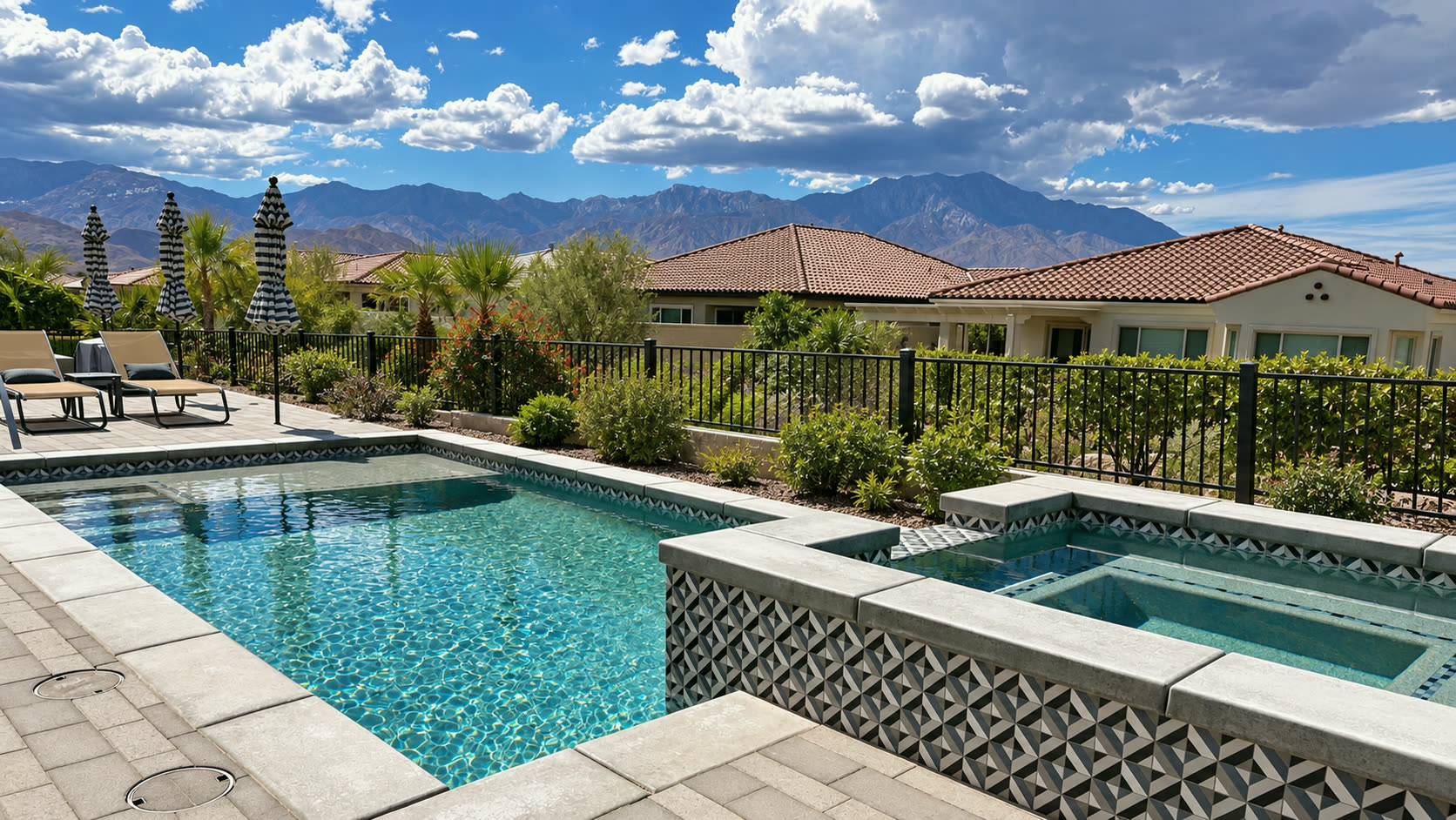 A pool and spa behind tile-roofed homes, with the desert mountains beyond.